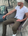 man wearing khaki green athletic pants outdoors, lifestyle image