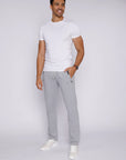 tall confident male model wearing light grey long-inseam athletic sweat pants, lifestyle view