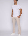 tall male model wearing beige long inseam sweatpants, full-body lifestyle angle