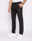 Person wearing black jogger pants with a white background