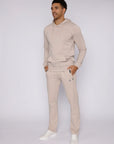 man styled in beige athletic pants and hoodie, lifestyle view
