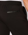 Detailed view of rear zipper pocket and elastic waistband on men's black relaxed-fit straight leg athletic pants - SCR Sportswear