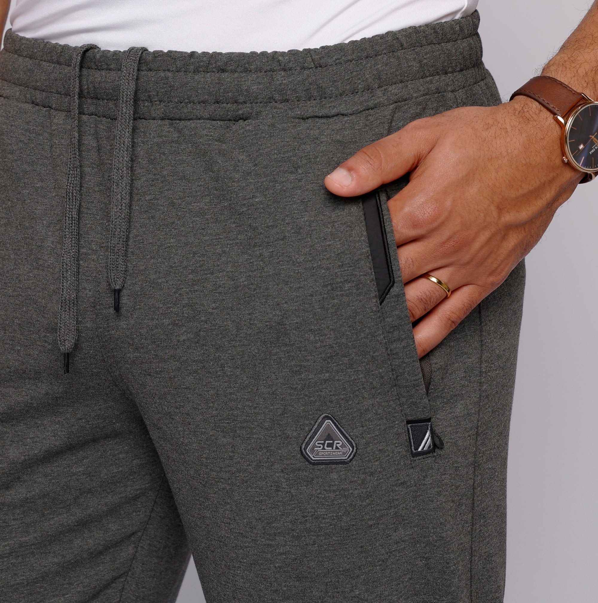 close-up of dark gray sweatpants showing zipper pocket detail 