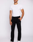 big and tall male model wearing black long-inseam athletic sweatpants, full-body lifestyle view