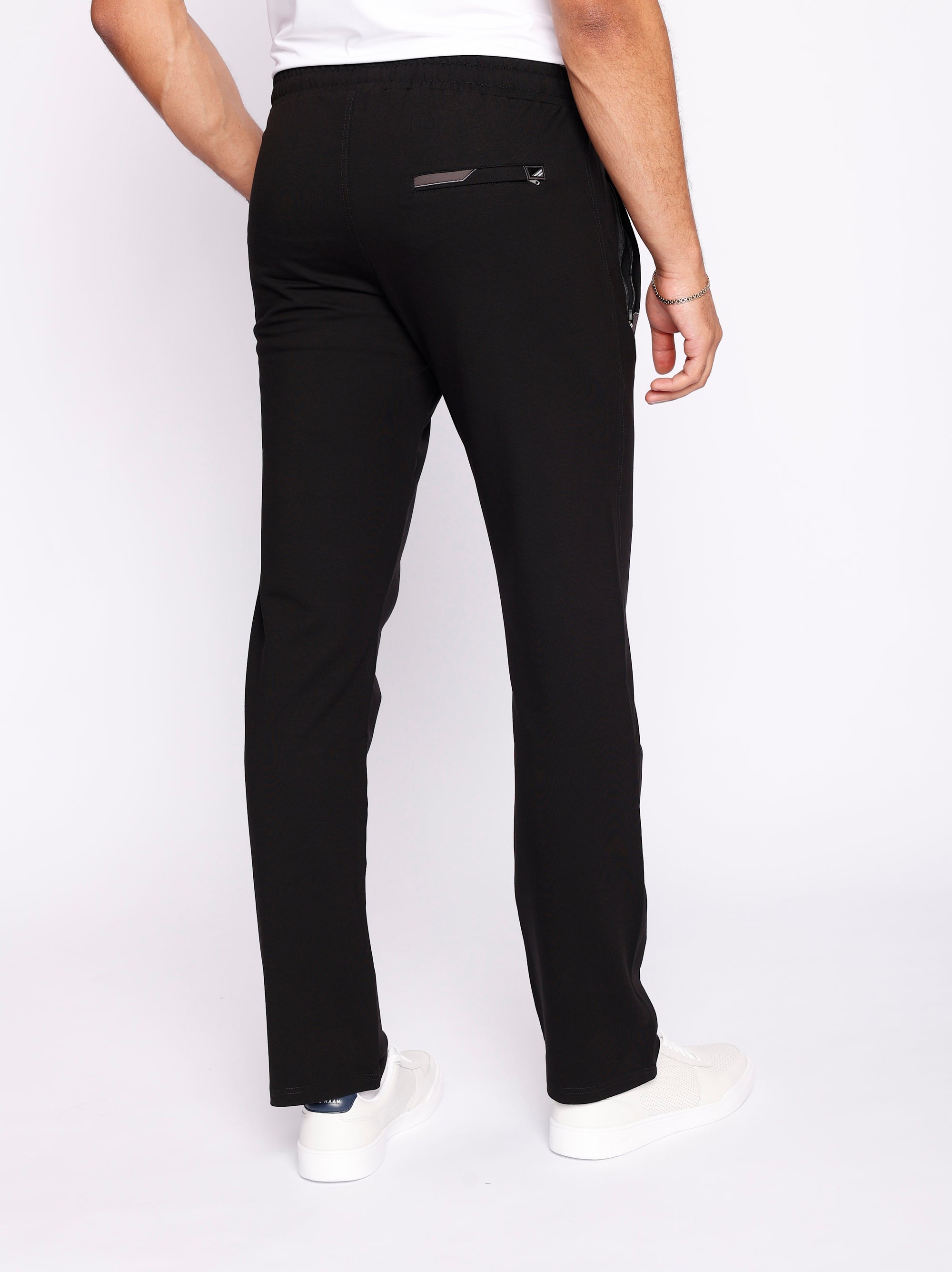 back  view of men’s black sweatpants with straight leg cut, zippered back pocket, and stretch waistband, worn by male 