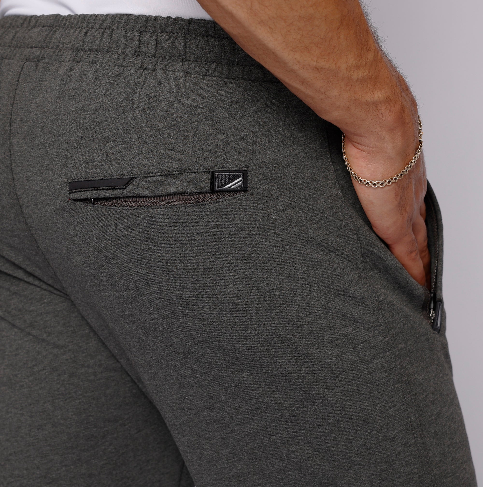 close-up of tall men’s dark grey sweatpants with secure back zipper pocket