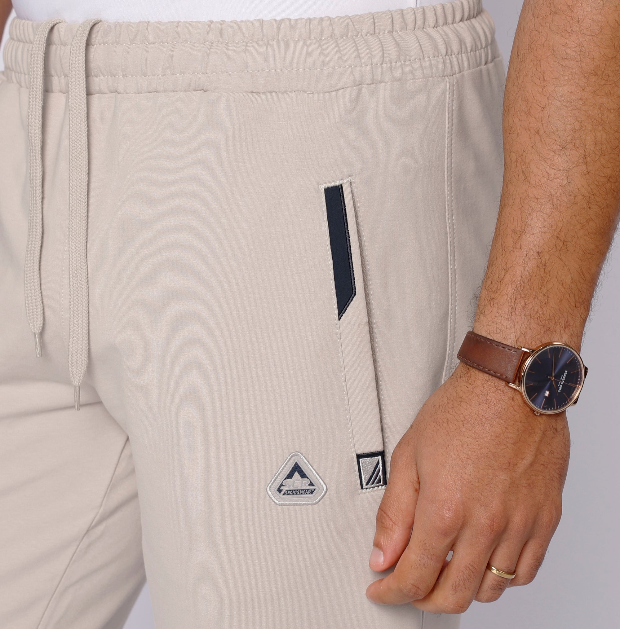 close-up of beige tall men’s athletic sweatpants with zipper front pocket