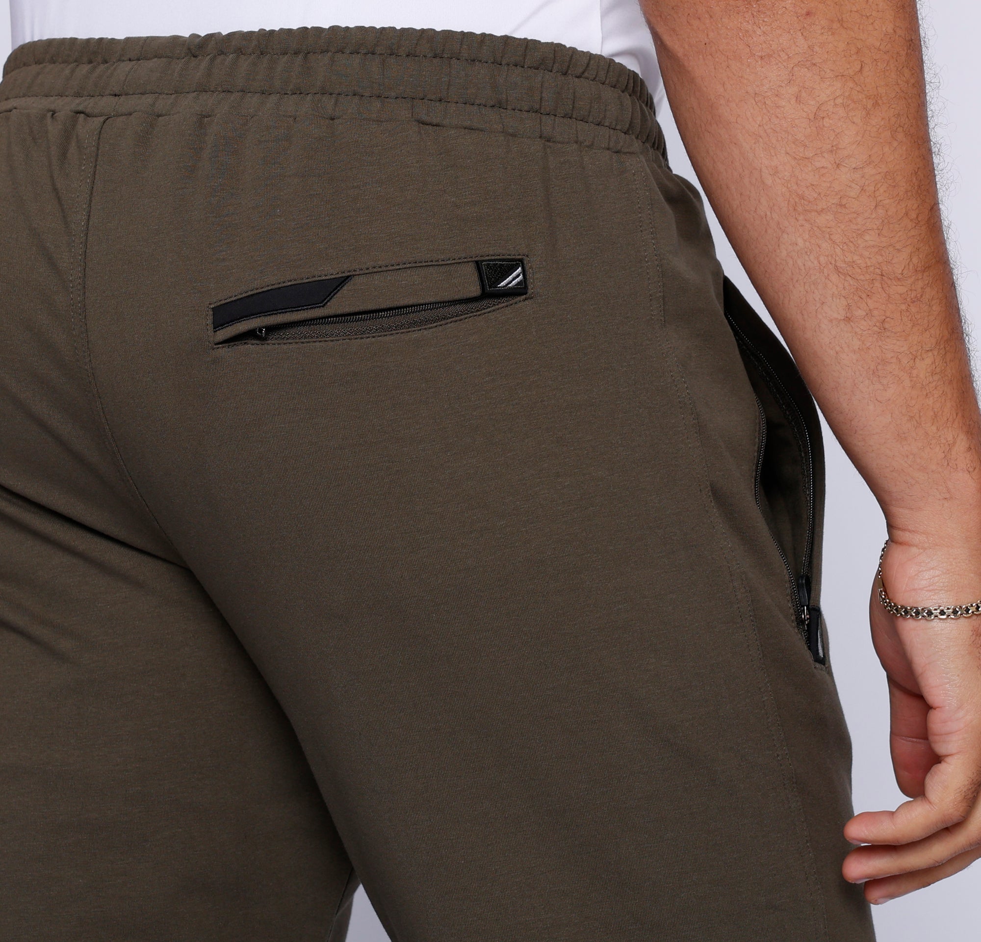 close-up of khaki green sweatpants back zippered pocket stitching