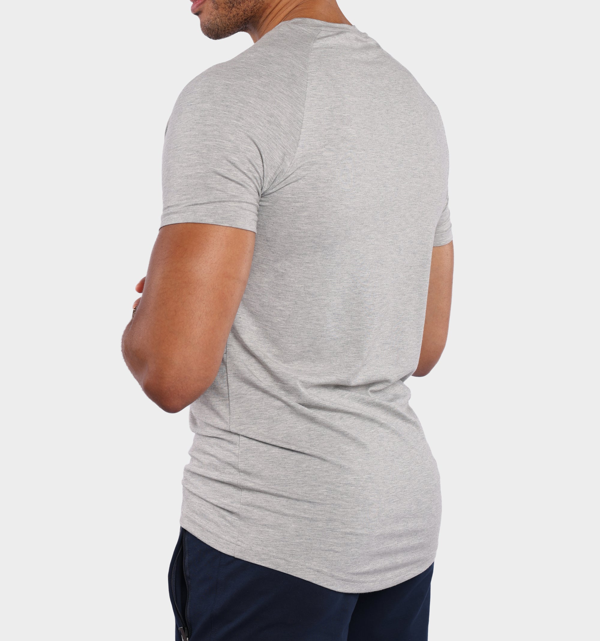 A man wearing a light gray heathered short-sleeve t-shirt, shown from a rear three-quarter angle against a plain light gray background.